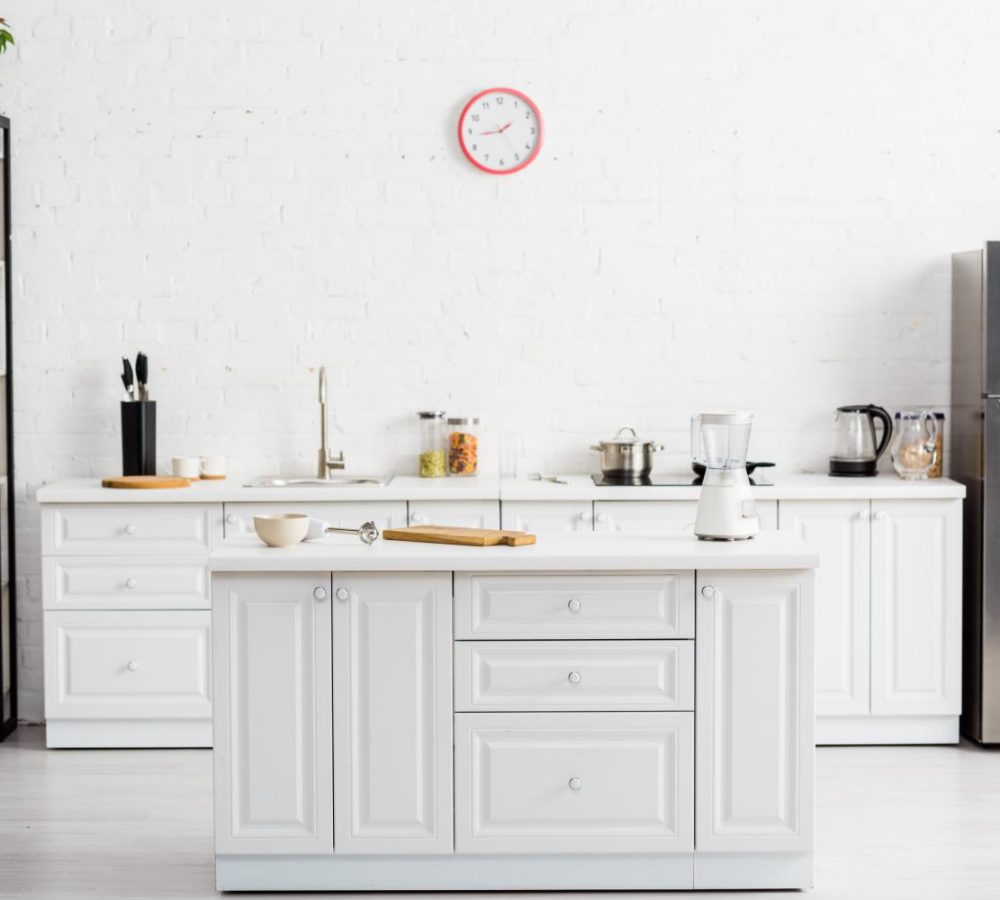 modern white kitchen with table and kitchenware and fridge