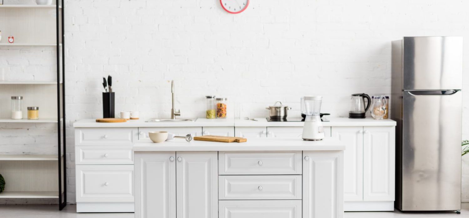 modern white kitchen with table and kitchenware and fridge